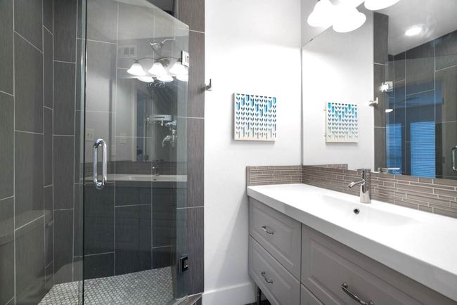 Bathroom with vanity, a shower stall, and tasteful backsplash | Image 11