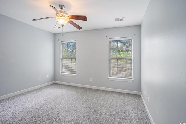 Carpeted empty room with baseboards and a ceiling fan | Image 10