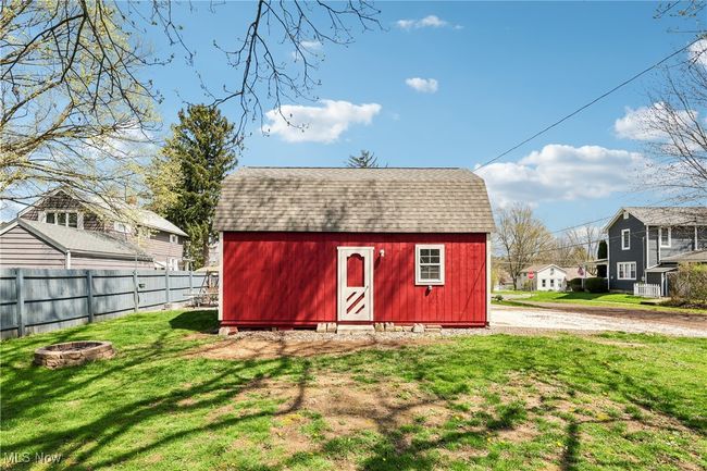 View of barn featuring a residential view, a lawn, fence, and an outdoor fire pit | Image 31