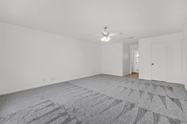 Empty room with carpet flooring, ceiling fan, and baseboards | Image 26