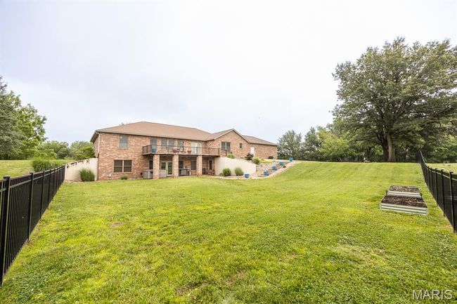 Back of house featuring brick siding and a garden | Image 47