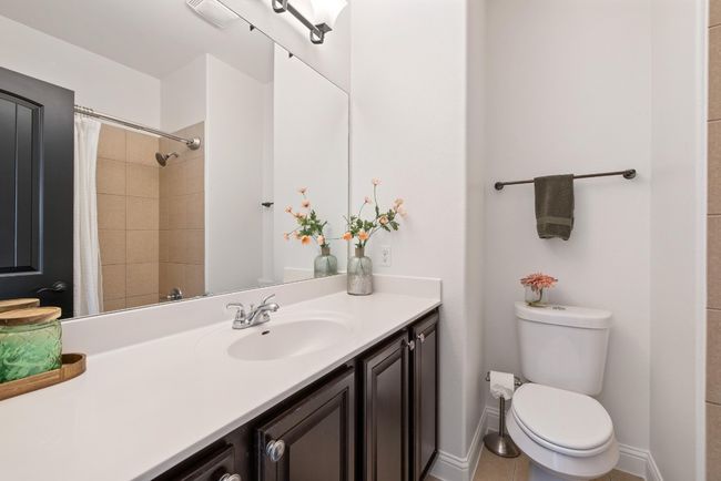 Bathroom with toilet, a shower with curtain, and vanity | Image 36