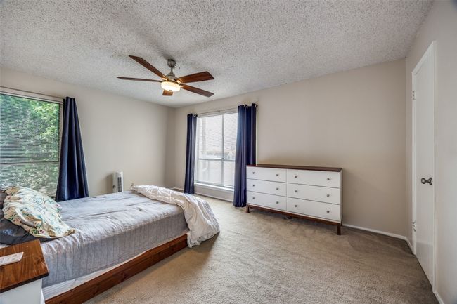 Bedroom featuring carpet flooring, a textured ceiling, and ceiling fan | Image 11