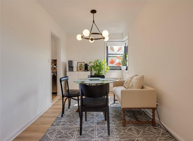 Dining room with a chandelier, wood finished floors, radiator, and baseboards | Image 8