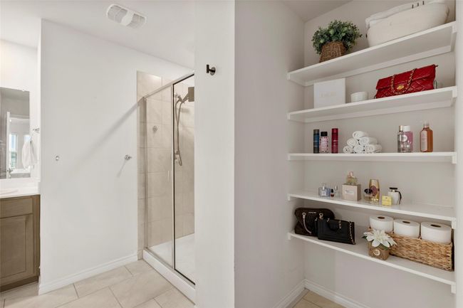 Bathroom featuring tile patterned floors, visible vents, baseboards, a shower stall, and vanity | Image 16