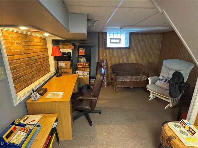 Carpeted office space featuring wooden walls and a paneled ceiling | Image 9
