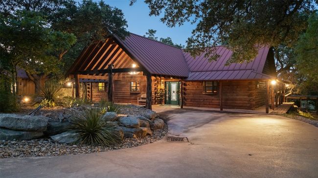Log cabin with a standing seam roof, log exterior, a metal roof, and concrete driveway | Image 25