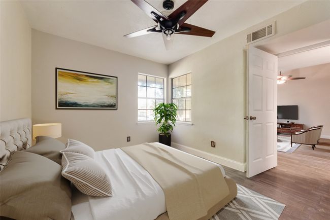 Bedroom featuring wood finished floors, an office area, and a ceiling fan | Image 9