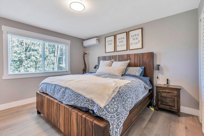 Bedroom featuring baseboards, a wall mounted air conditioner, and light wood finished floors | Image 20