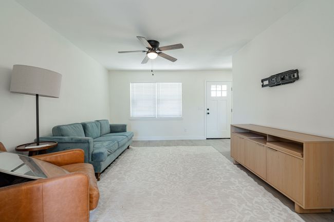 Living area with a ceiling fan and light wood-type flooring | Image 4