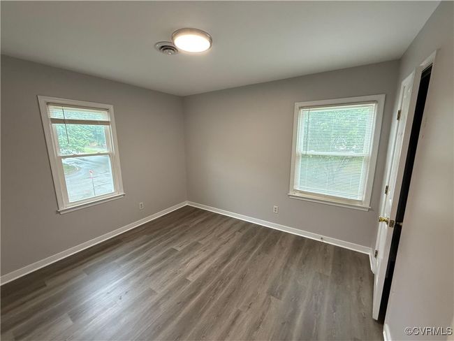Spare room with dark wood-style flooring and baseboards | Image 6