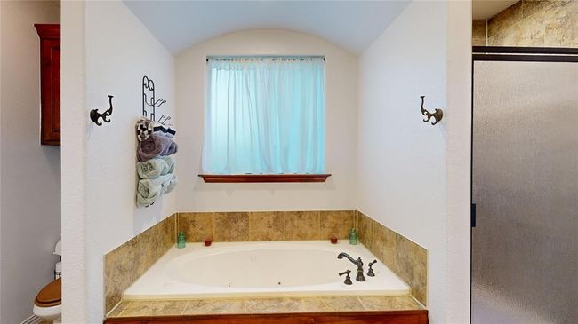Bathroom with a shower stall, vaulted ceiling, and a whirlpool tub | Image 37
