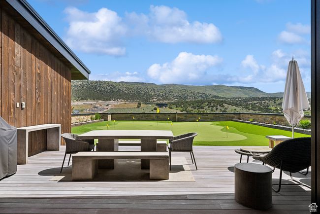Deck featuring an area to practice putting, a mountain view, and golf course view | Image 116