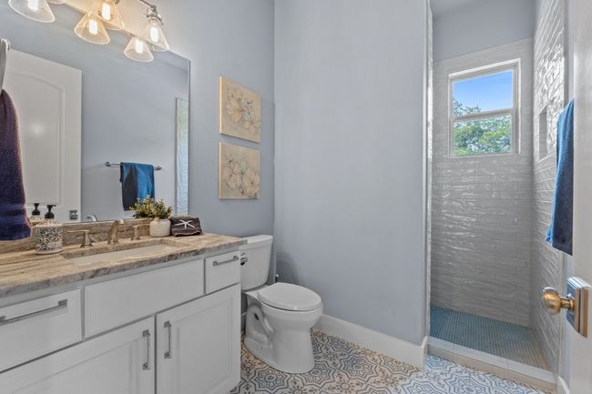 Bathroom with tile patterned floors, toilet, baseboards, vanity, and a walk in shower | Image 27