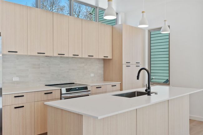 Kitchen featuring modern cabinets, a sink, stainless steel electric range, and light brown cabinetry | Image 8