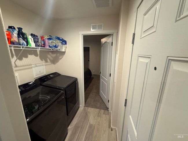 Laundry room with washing machine and dryer and light wood-style flooring | Image 11