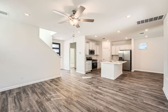 Kitchen with visible vents, ceiling fan, open floor plan, appliances with stainless steel finishes, and a sink | Image 7
