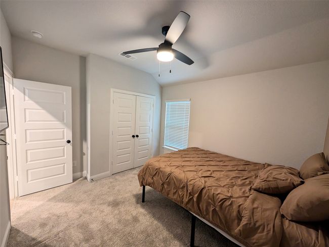 Bedroom featuring ceiling fan, a closet, visible vents, light carpet, and lofted ceiling | Image 7