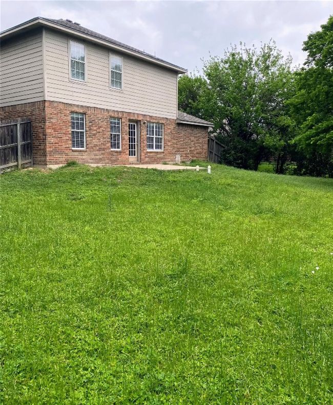 Rear view of property featuring fence, a lawn, and brick siding | Image 24
