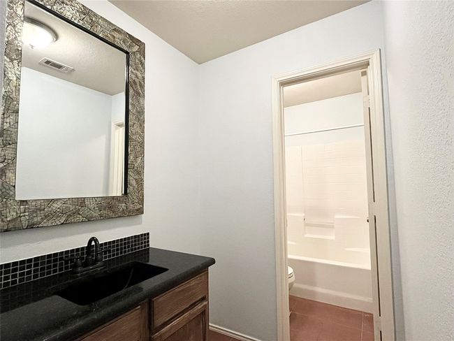 Full bath with vanity, tile patterned floors, decorative backsplash, and shower combination | Image 20