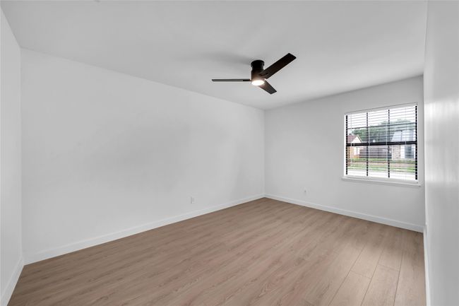 Spare room with wood finished floors, a ceiling fan, and baseboards | Image 20
