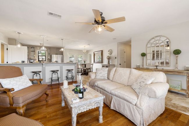 Living area featuring a ceiling fan and wood finished floors | Image 16