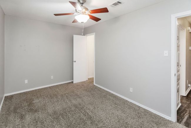 Unfurnished room featuring ceiling fan and dark colored carpet | Image 25