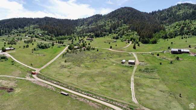 Aerial view of property's location with a heavily wooded area, rural landscape, and mountains | Image 7