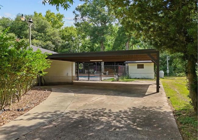 Covered double carport with easy access to backyard and pool area. | Image 15