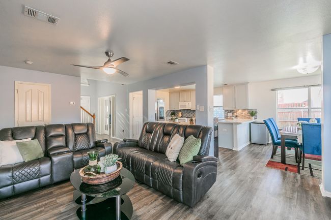 Living area with wood finished floors and a ceiling fan | Image 12