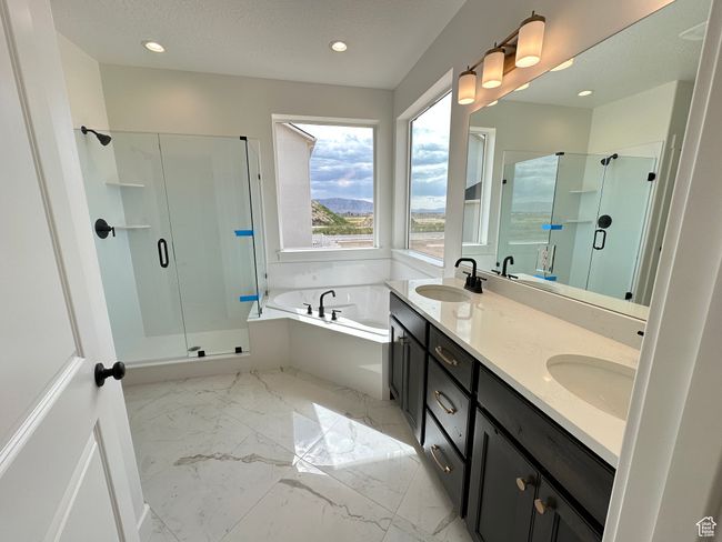 Bathroom with a stall shower, a bath, marble finish flooring, double vanity, and recessed lighting | Image 16