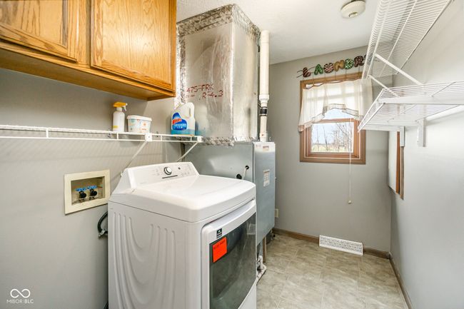 laundry area featuring baseboards, cabinet space, visible vents, and washer / dryer | Image 9