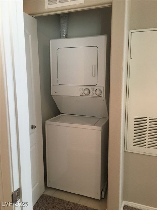 Laundry area featuring estacked washer and dryer and tile patterned flooring | Image 5