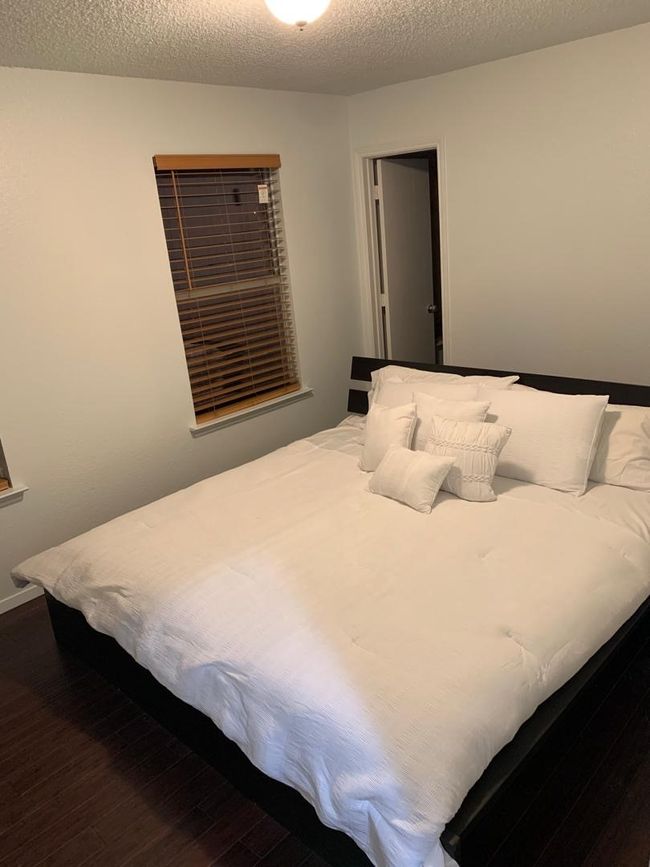 Bedroom with dark wood-style flooring and a textured ceiling | Image 25
