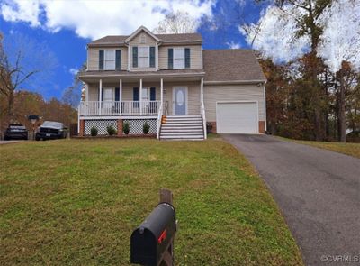 View of front of home featuring a porch, a garage, and a front lawn | Image 1