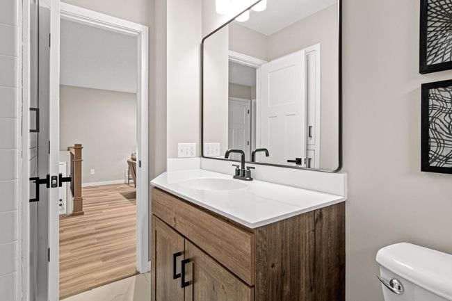 Full bathroom on the upper level has a new cabinet, faucets, mirror, light fixtures, and flooring. | Image 11