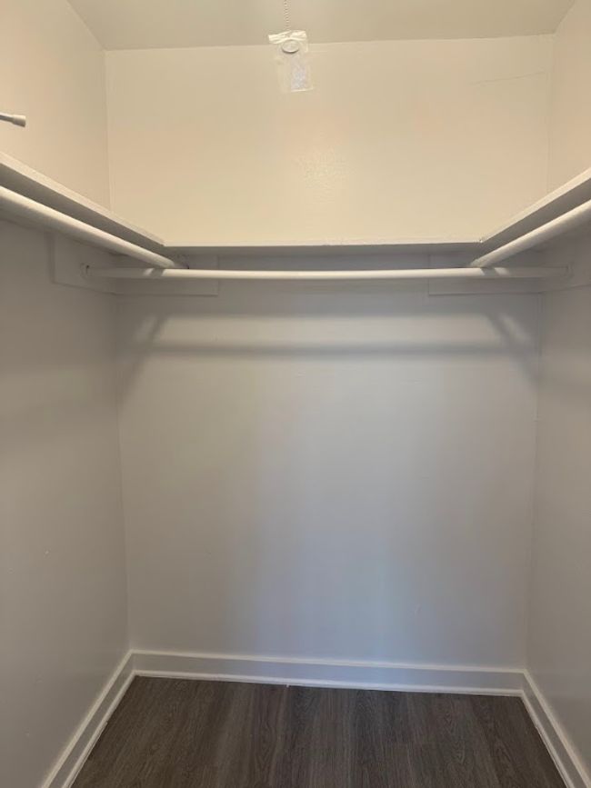 Walk in closet with dark wood finished floors | Image 21