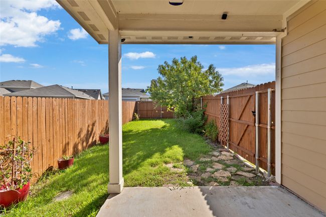 Fenced backyard with a gate and a patio area | Image 29