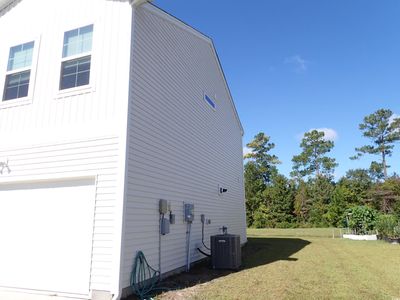 View of home's exterior featuring cooling unit, a garage, and a lawn | Image 2