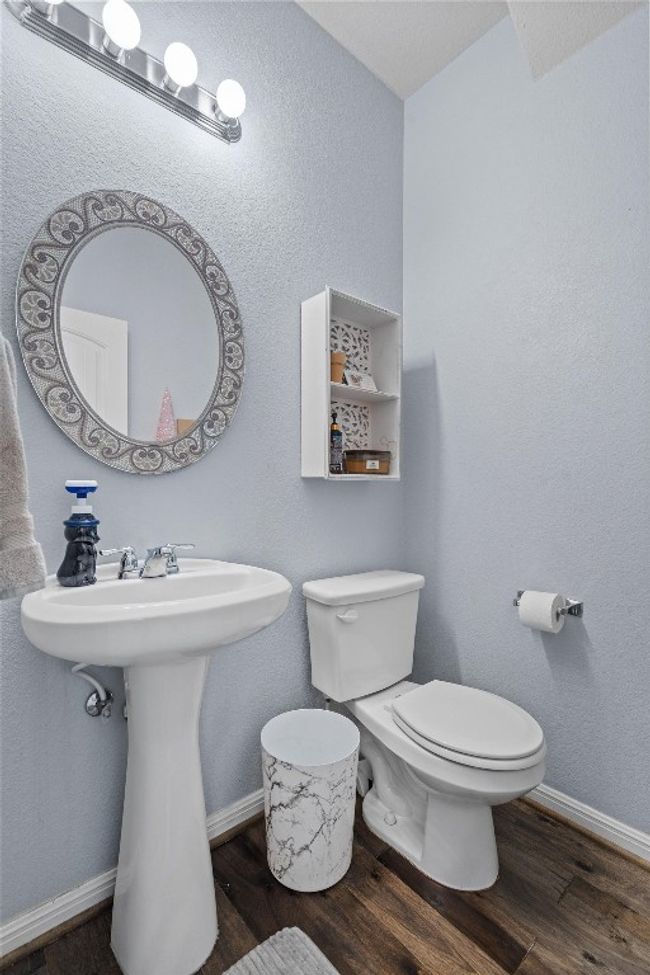Half bath featuring toilet, wood finished floors, baseboards, and a sink | Image 22