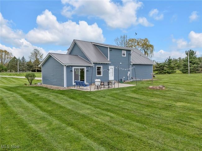 Back of property with metal roof, a yard, and a patio area | Image 36