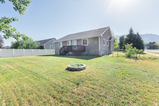 Back of house with a fenced backyard, stucco siding, and a deck with mountain view | Image 24