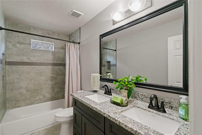 Second upstairs bathroom with the following updates: granite countertop, sinks and faucets, bathtub and tile in shower area and bathroom floor. | Image 32