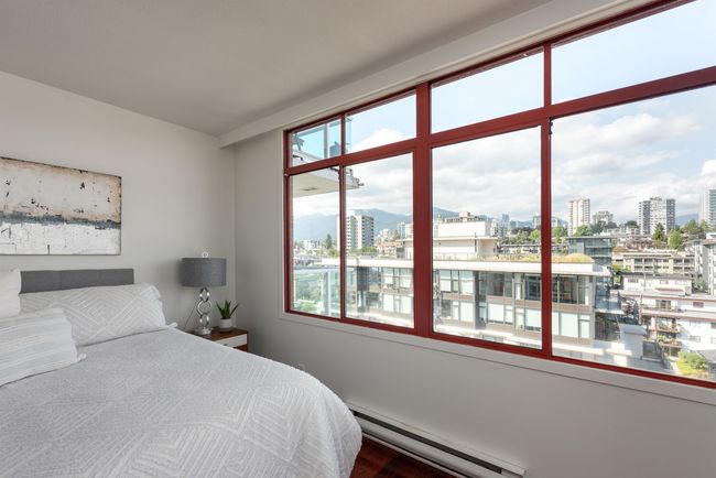 Bedroom with baseboard heating, a city view, and wood finished floors | Image 25
