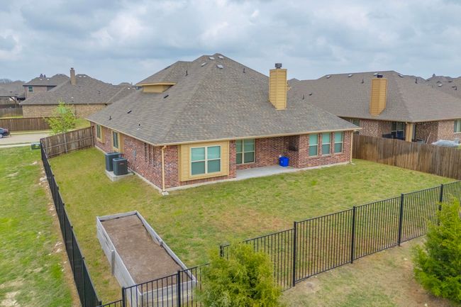 Back of property with a fenced backyard, brick siding, a chimney, and a lawn | Image 15