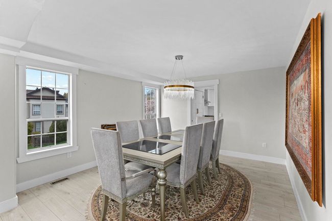 Dining space with light wood-style flooring, baseboards, and an inviting chandelier | Image 7