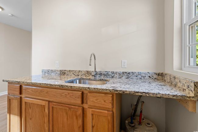 Kitchen featuring light stone countertops, brown cabinets, and light wood-style floors | Image 34