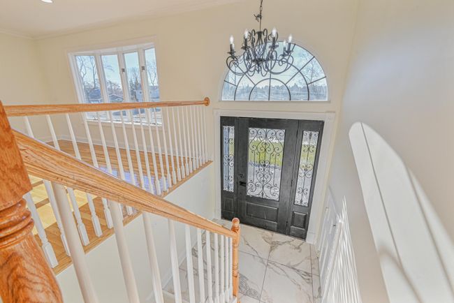 Foyer entrance featuring a towering ceiling and a notable chandelier | Image 23