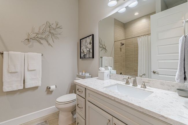 Bathroom with toilet, tiled shower, vanity, wood finished floors, and baseboards | Image 22