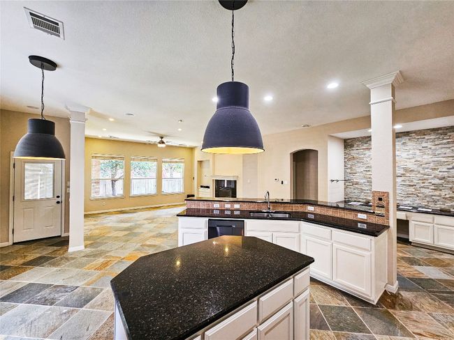 Kitchen featuring ornate columns, a sink, open floor plan, stone tile flooring, and recessed lighting | Image 11